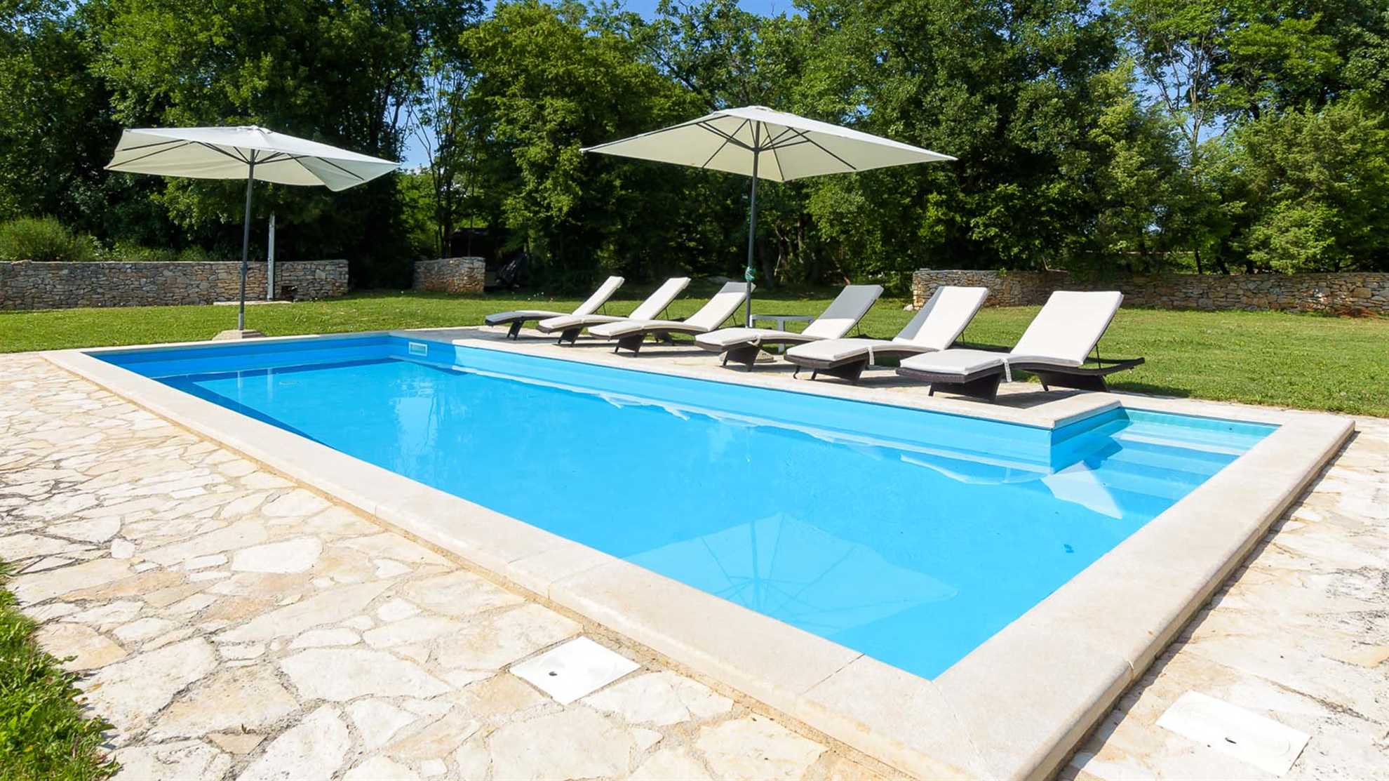 A traditional, stone villa in Marčana with a pool and children's playground