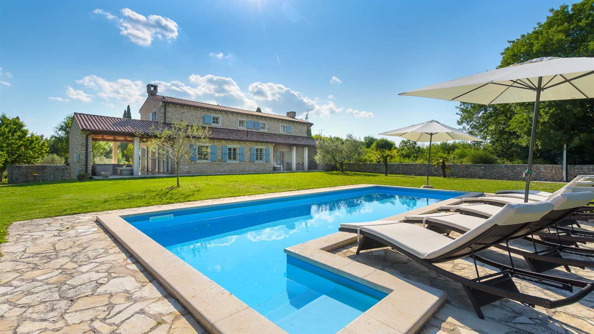 A traditional, stone villa in Marčana with a pool and children's playground
